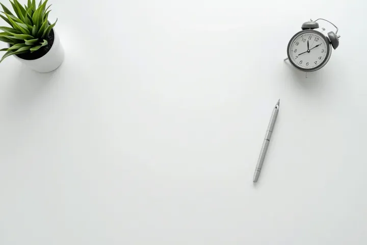 A tidy minimalist desk with a notebook and pen, soft daylight